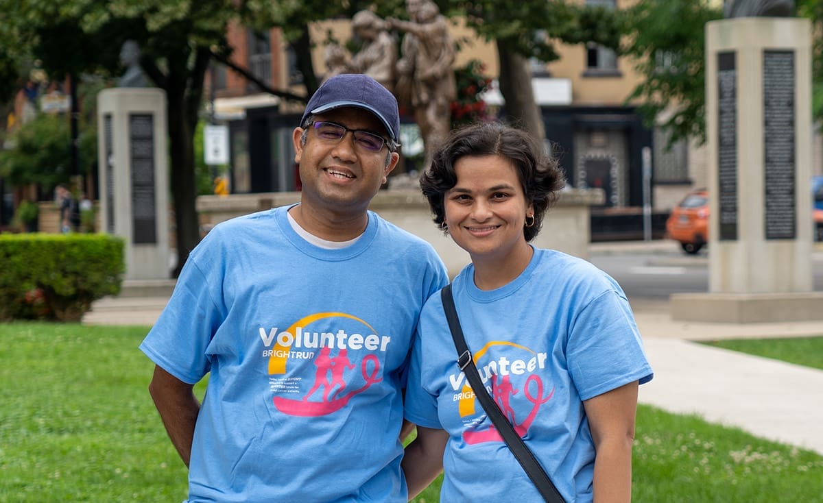 Photo of Dr. Saha and her husband wearing blue volunteer t-shirts